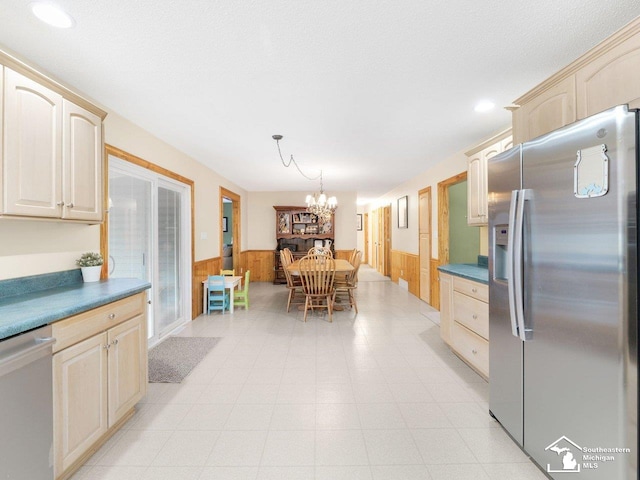 kitchen featuring wooden walls, wainscoting, and stainless steel appliances