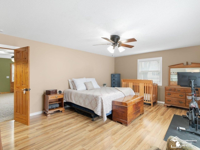 bedroom with a textured ceiling, baseboards, light wood finished floors, and ceiling fan