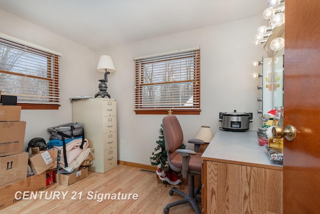 office area featuring visible vents, baseboards, and light wood finished floors