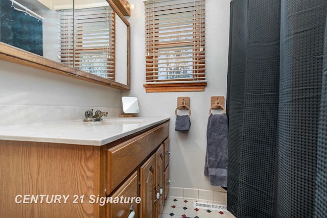 full bath featuring visible vents, vanity, a shower with shower curtain, and baseboards