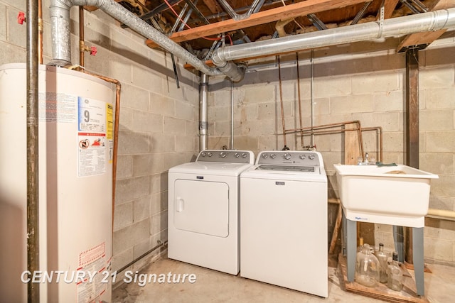 washroom with a sink, washing machine and clothes dryer, water heater, and laundry area