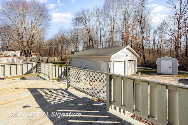 deck featuring a garage, an outdoor structure, and fence