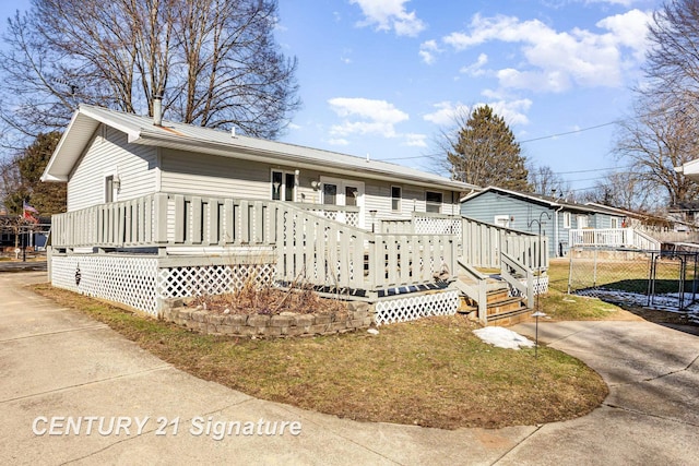 view of front of property featuring a deck, concrete driveway, and metal roof