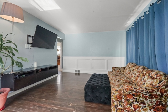 sitting room featuring visible vents, a decorative wall, wood finished floors, and a wainscoted wall