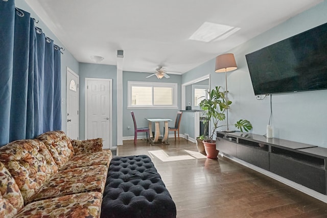 living room with a ceiling fan, wood finished floors, and baseboards