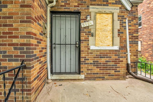 doorway to property featuring brick siding