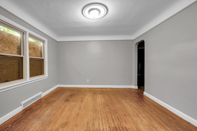 5984 Courville St, Detroit, MI 48224 - spare room featuring visible vents, arched walkways, baseboards, and wood finished floors