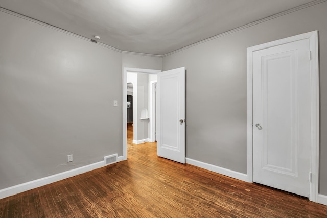 5984 Courville St, Detroit, MI 48224 - unfurnished bedroom with wood finished floors, visible vents, and baseboards