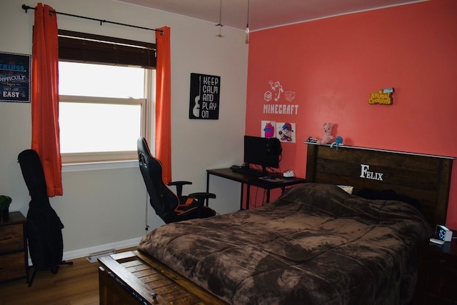 bedroom featuring wood finished floors and baseboards