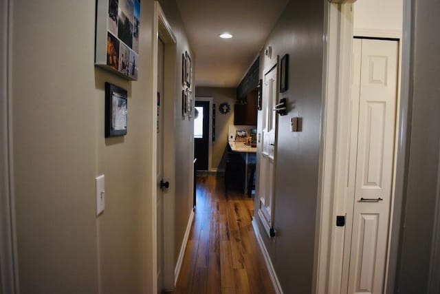 hallway featuring recessed lighting, baseboards, and dark wood finished floors