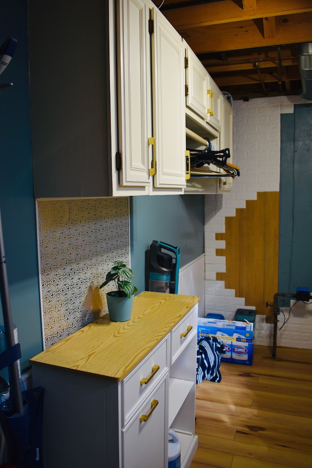 kitchen featuring wooden counters, white cabinetry, and wood finished floors