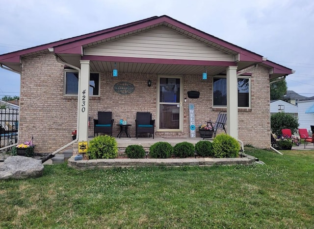 bungalow-style home featuring brick siding, covered porch, and a front lawn