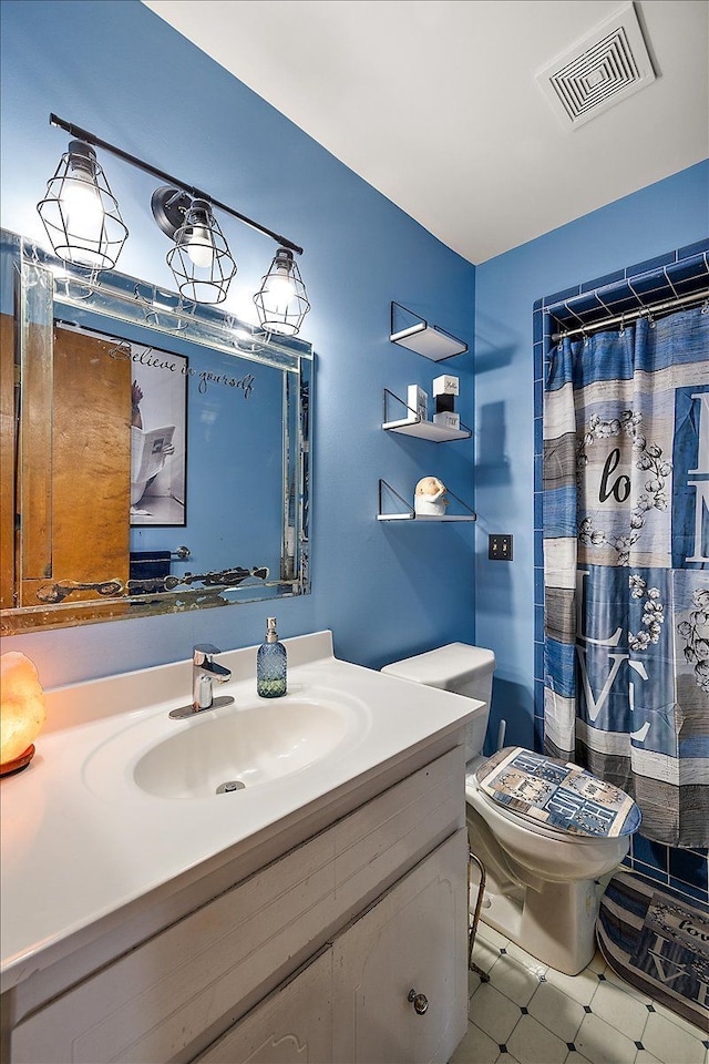 bathroom featuring visible vents, toilet, vanity, and a shower with curtain