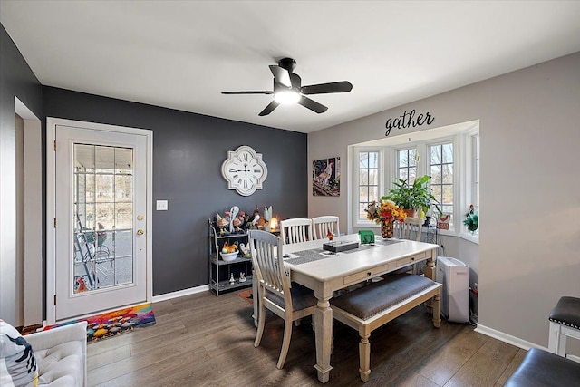 dining space featuring wood finished floors, baseboards, and ceiling fan