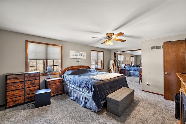 carpeted bedroom featuring a ceiling fan, baseboards, and visible vents