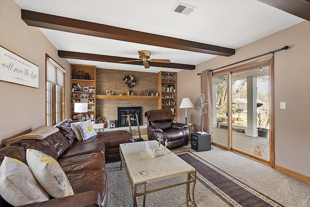 carpeted living room with beam ceiling, a brick fireplace, baseboards, and visible vents