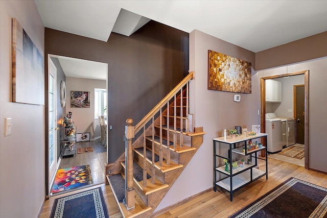 stairway with baseboards, washer / clothes dryer, and hardwood / wood-style flooring