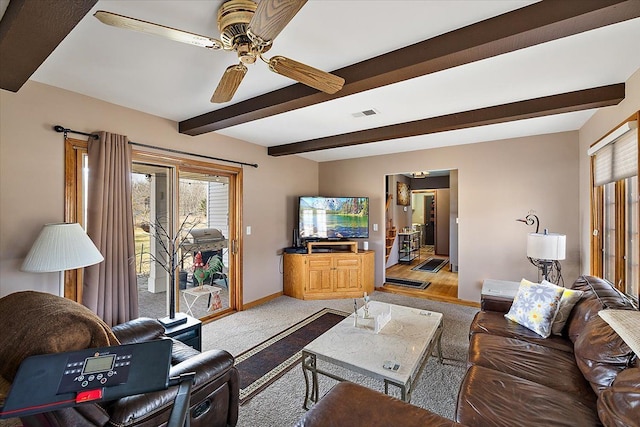 living room with baseboards, visible vents, ceiling fan, beamed ceiling, and light colored carpet