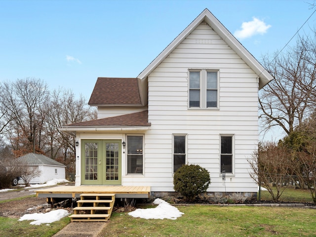 back of property with a yard, french doors, a shingled roof, and a deck