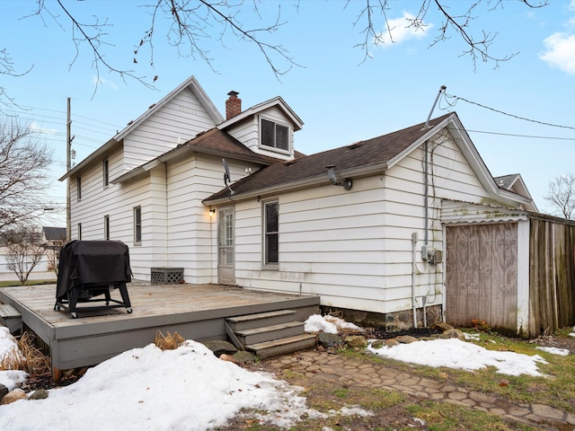 back of house featuring a chimney and a wooden deck