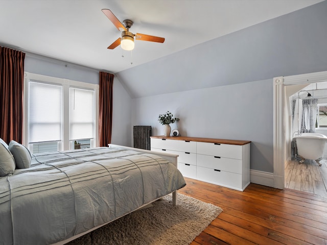 bedroom featuring vaulted ceiling, hardwood / wood-style flooring, a ceiling fan, and baseboards