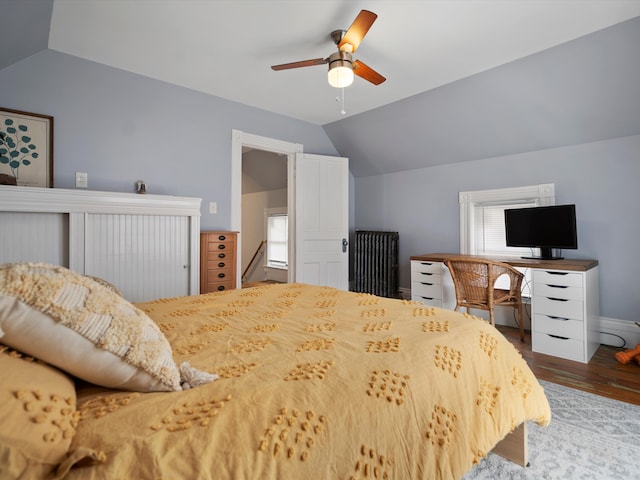 bedroom featuring a ceiling fan, lofted ceiling, wood finished floors, and baseboards