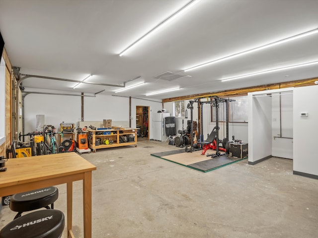 garage with a workshop area and freestanding refrigerator