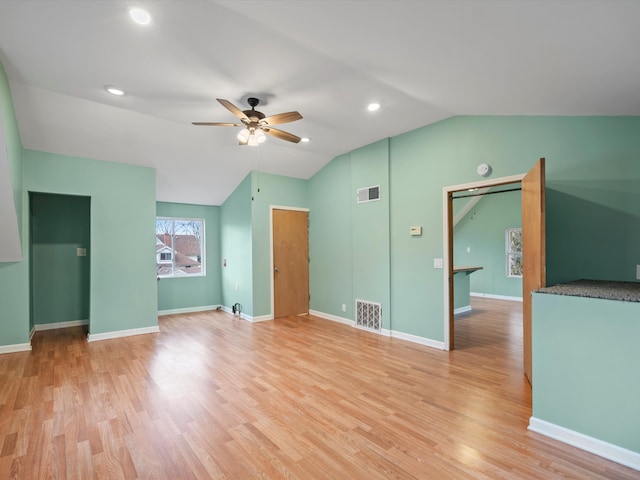 unfurnished living room featuring visible vents, light wood-style flooring, a ceiling fan, and vaulted ceiling