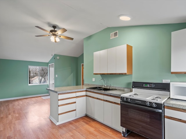 kitchen with visible vents, a sink, range with gas cooktop, a peninsula, and white microwave