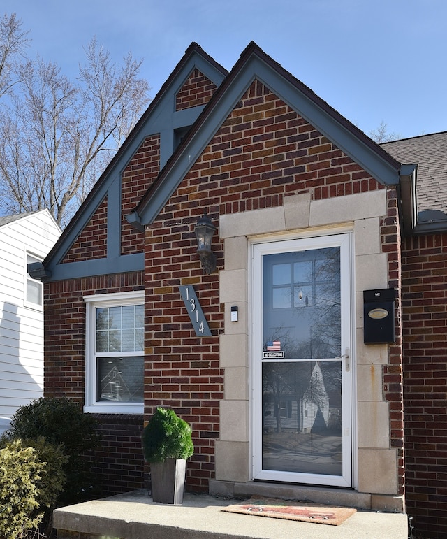 doorway to property featuring brick siding