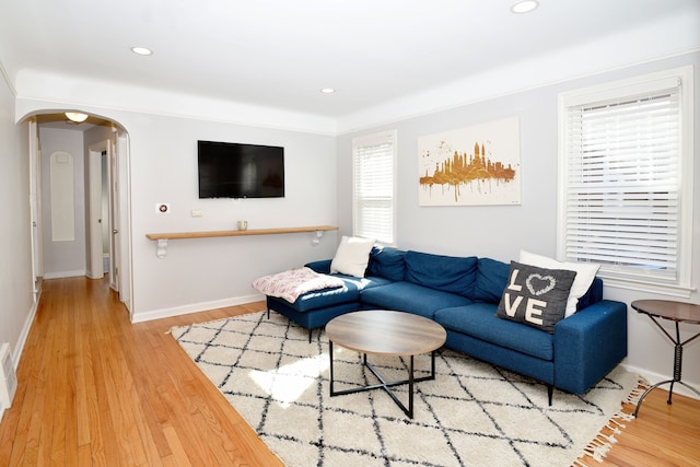 living area with recessed lighting, arched walkways, and wood finished floors