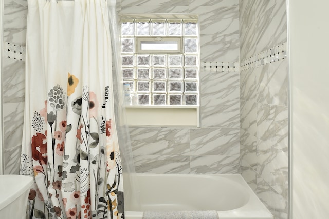 bathroom featuring toilet and shower / bathtub combination with curtain