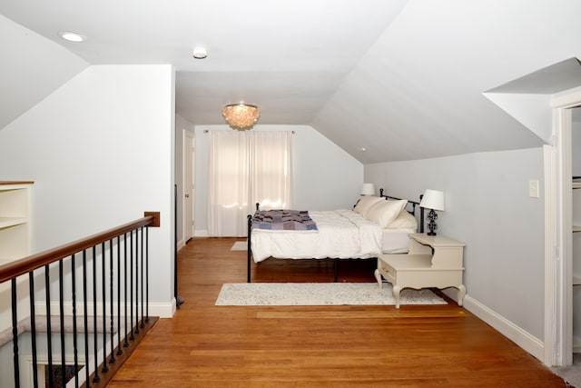 bedroom featuring vaulted ceiling, wood finished floors, and baseboards