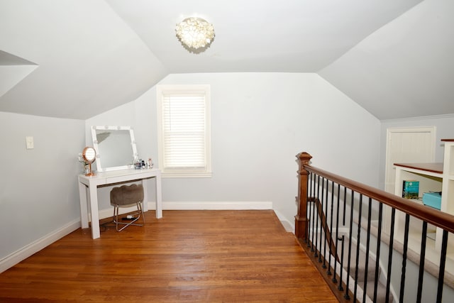 interior space featuring baseboards, lofted ceiling, and wood finished floors