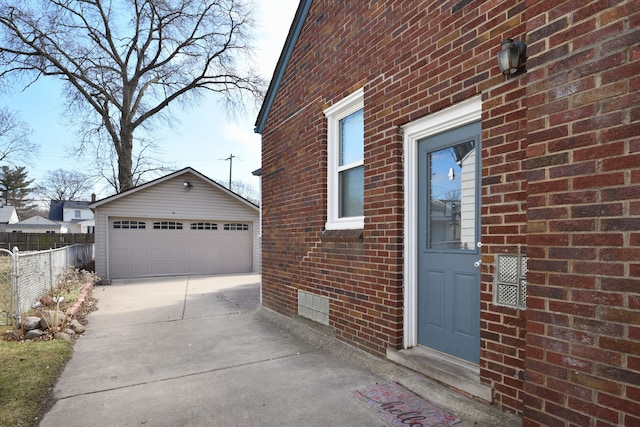 exterior space featuring brick siding, an outbuilding, a garage, and fence