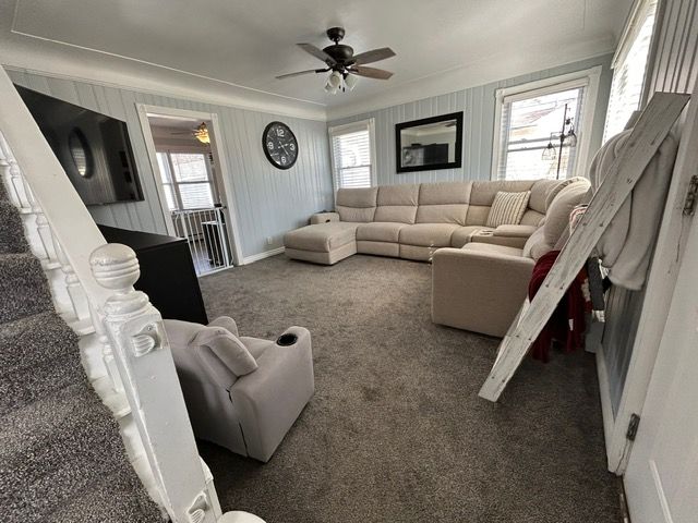 living area featuring a ceiling fan and carpet