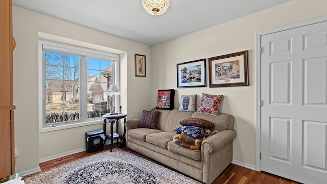 living area featuring visible vents, dark wood-style floors, and baseboards