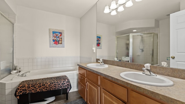 full bathroom featuring double vanity, a bath, a stall shower, and a sink