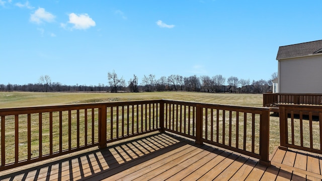 wooden terrace featuring a rural view and a lawn