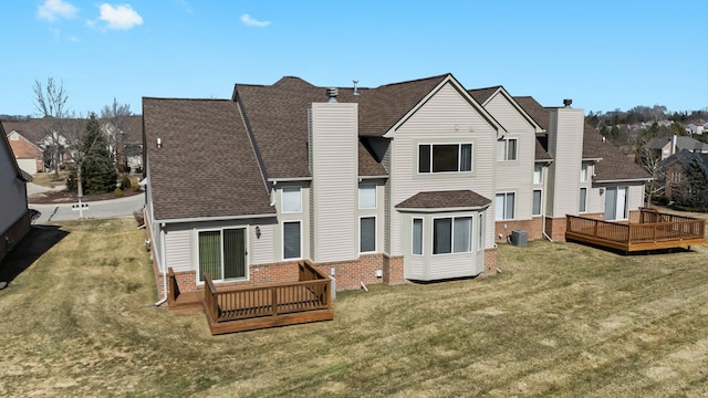 back of property featuring brick siding, a yard, and a deck