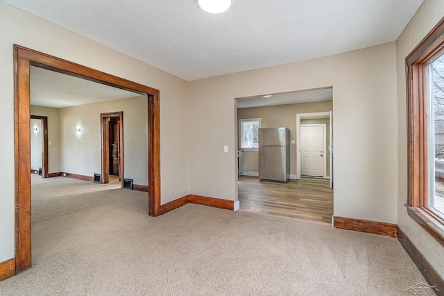 empty room with baseboards and carpet