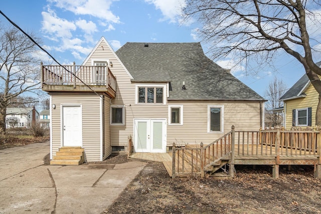 back of house with roof with shingles, a deck, and entry steps