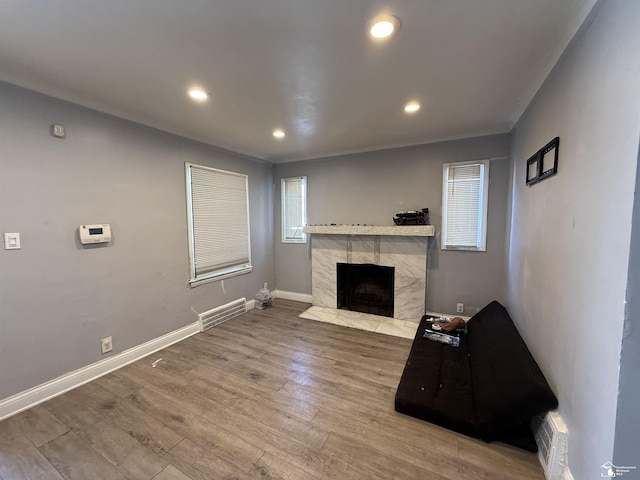 living area featuring visible vents, wood finished floors, a high end fireplace, recessed lighting, and baseboards