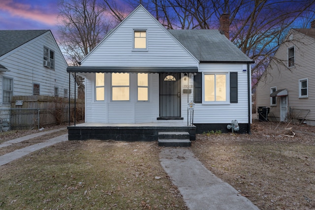 bungalow-style home with fence, covered porch, and a chimney