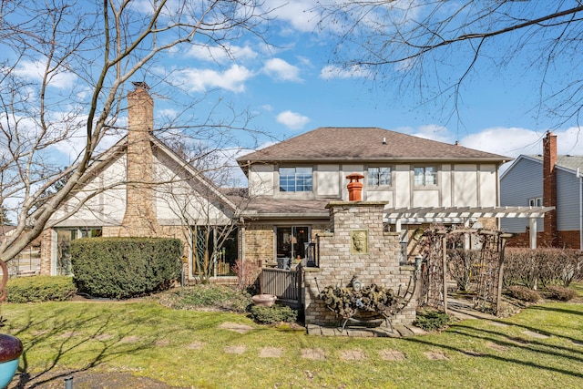 rear view of property featuring stucco siding, a lawn, a shingled roof, and a pergola