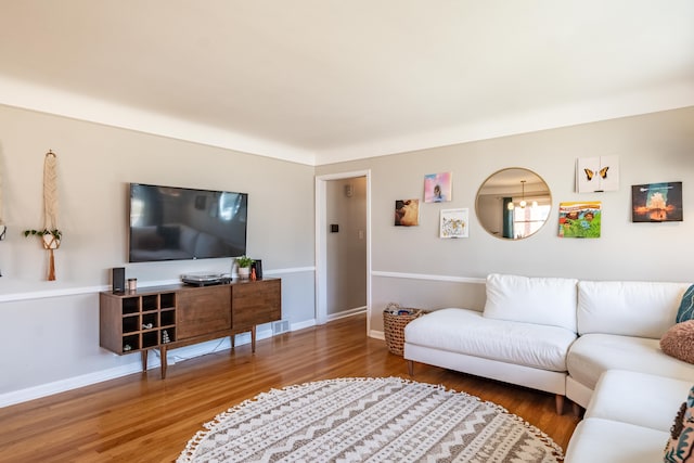 living area with baseboards and wood finished floors