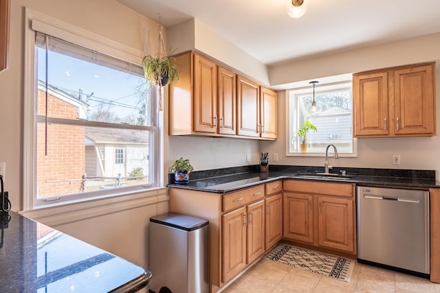 kitchen featuring light tile patterned floors, a sink, dark stone counters, and stainless steel dishwasher