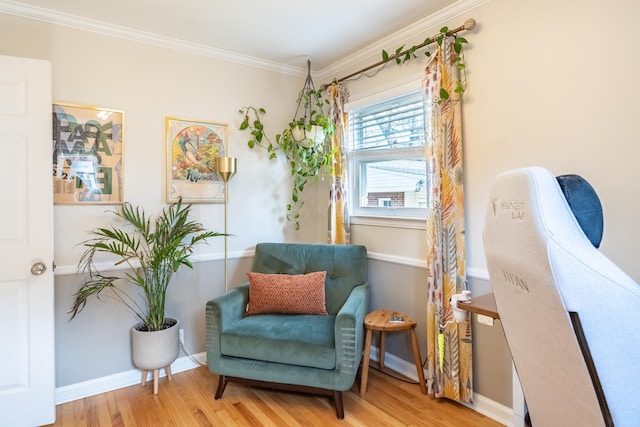 living area featuring ornamental molding, baseboards, and wood finished floors