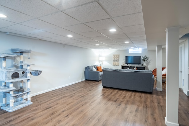 living room with recessed lighting, wood finished floors, baseboards, and a paneled ceiling