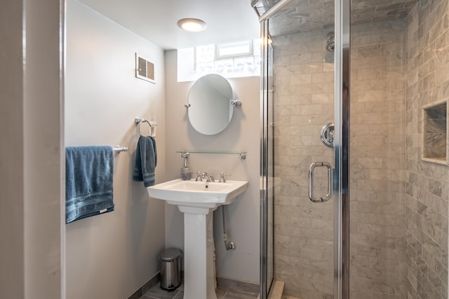 full bathroom with visible vents, a shower stall, baseboards, and a sink